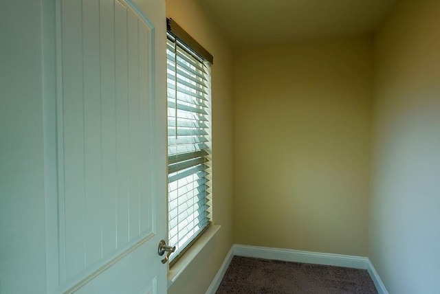 empty room featuring carpet floors and baseboards