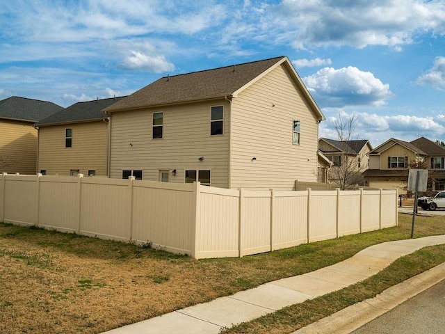 view of side of home featuring fence