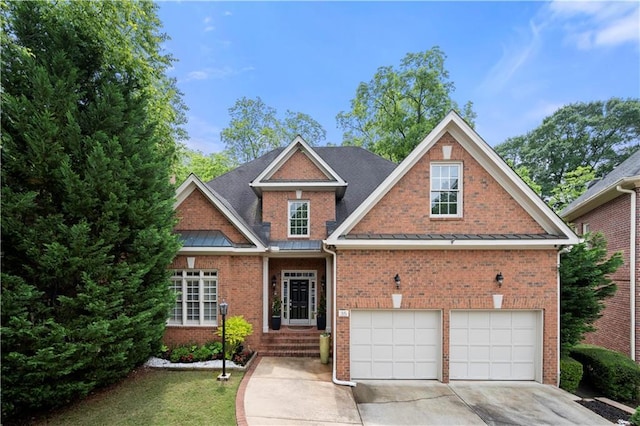 view of front facade featuring brick siding, driveway, a garage, and a standing seam roof