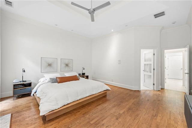 bedroom with crown molding, light wood-type flooring, baseboards, and a ceiling fan