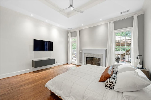 bedroom with crown molding, wood finished floors, recessed lighting, a high end fireplace, and baseboards
