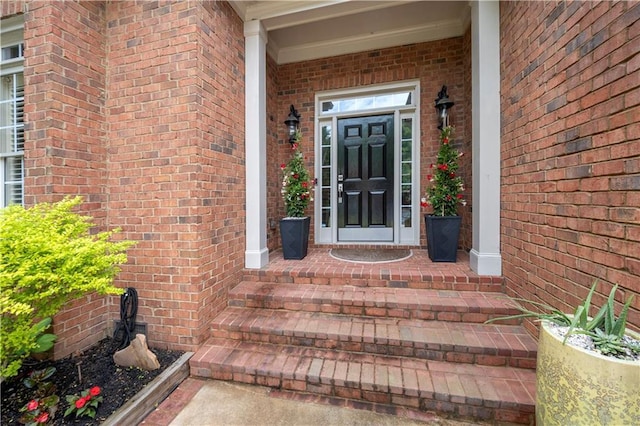 entrance to property featuring brick siding