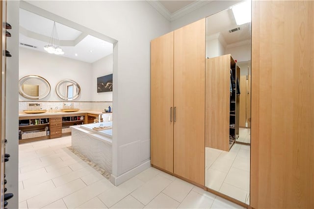 bathroom with crown molding, a garden tub, double vanity, a chandelier, and a closet