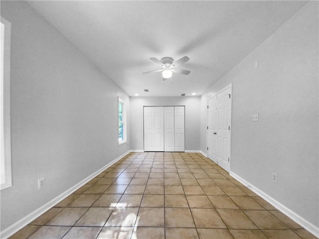 unfurnished bedroom featuring ceiling fan, a closet, and light tile patterned floors