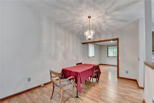 dining area featuring light hardwood / wood-style floors and a notable chandelier