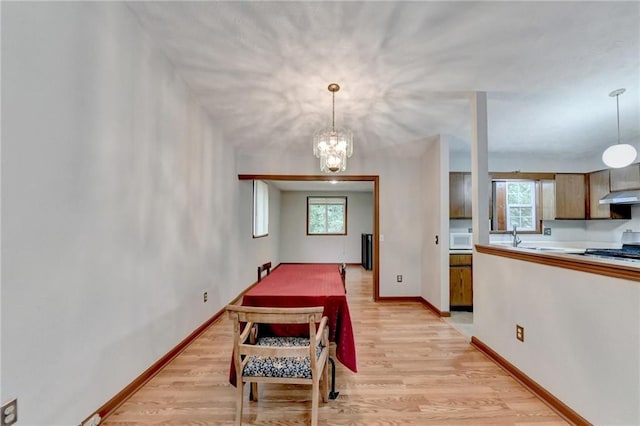 dining area featuring plenty of natural light, light hardwood / wood-style floors, and a chandelier