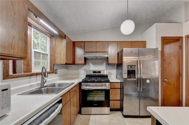 kitchen featuring light tile patterned flooring, vaulted ceiling, pendant lighting, stainless steel appliances, and sink