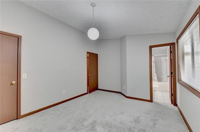 unfurnished bedroom with light carpet and vaulted ceiling