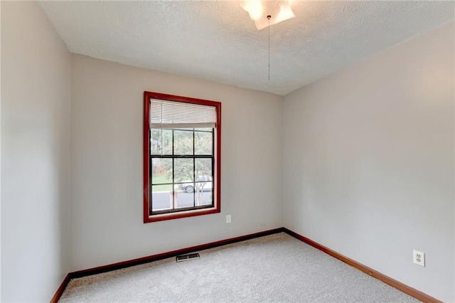 carpeted spare room with a textured ceiling