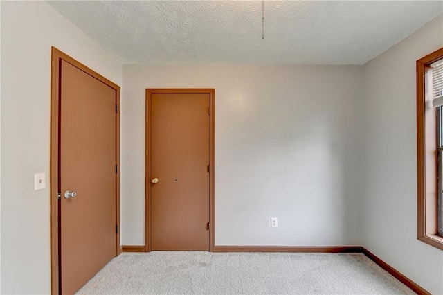 unfurnished room featuring a textured ceiling and carpet floors