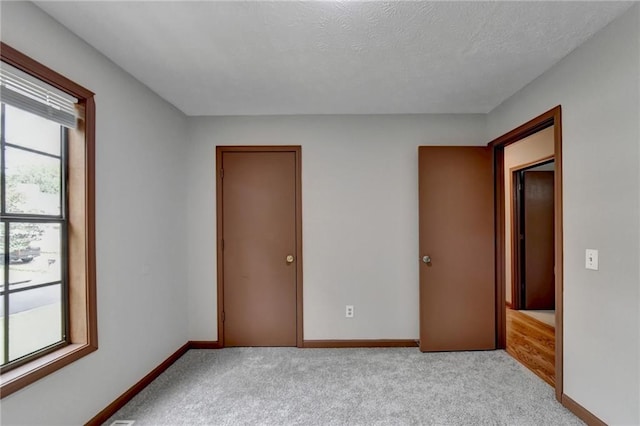 carpeted spare room featuring a textured ceiling