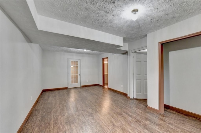 unfurnished room with wood-type flooring and a textured ceiling