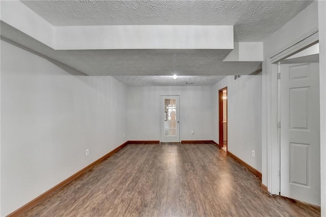 unfurnished room featuring a textured ceiling and hardwood / wood-style flooring