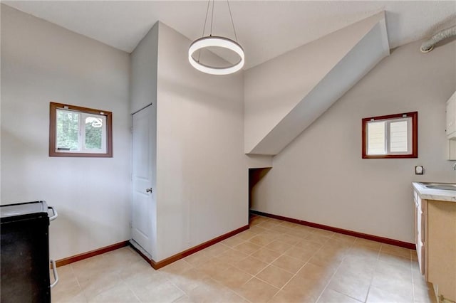 bonus room featuring a healthy amount of sunlight, sink, and light tile patterned floors