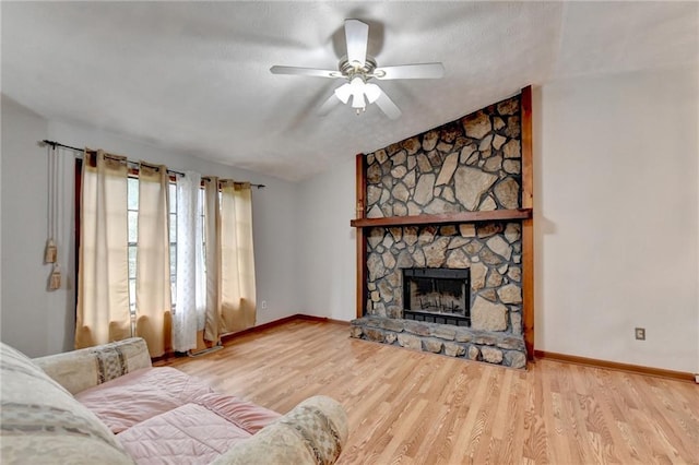 living room featuring light wood-type flooring, a fireplace, and ceiling fan