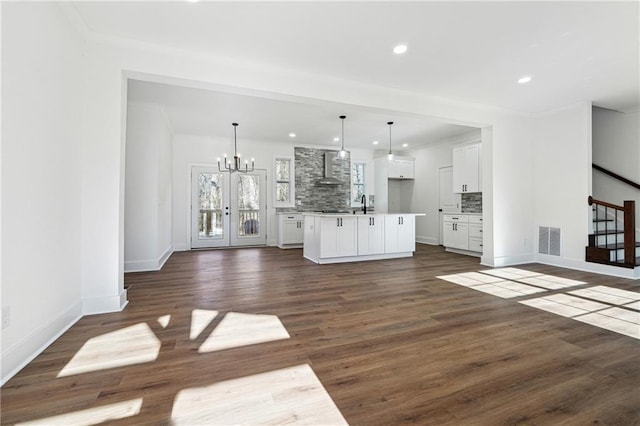 unfurnished living room with dark wood-type flooring, sink, and a notable chandelier