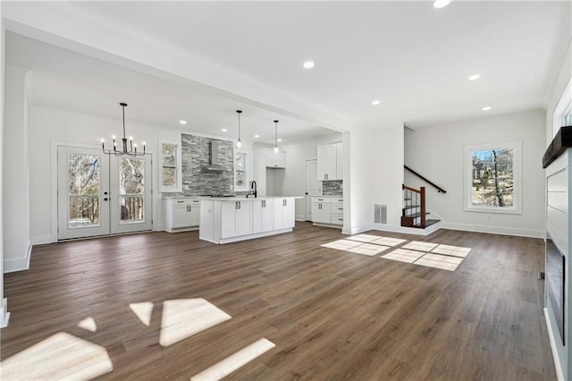 unfurnished living room with crown molding, dark hardwood / wood-style flooring, and sink