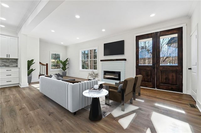 living room with ornamental molding, plenty of natural light, and dark wood-type flooring