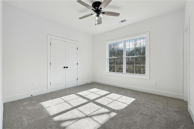 unfurnished bedroom featuring carpet floors, ceiling fan, and a closet