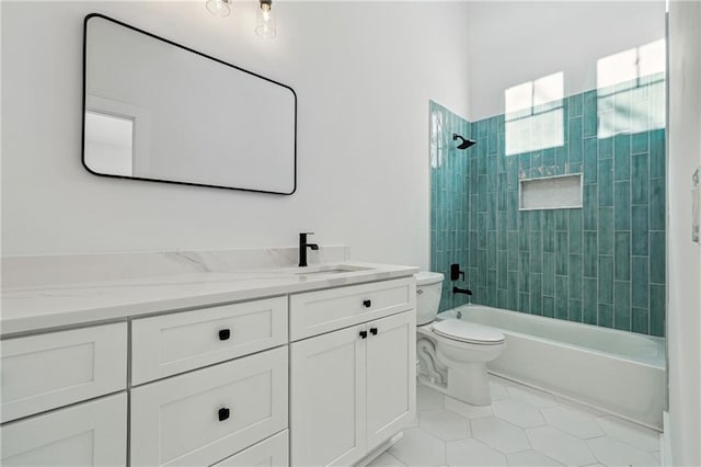 full bathroom with tile patterned flooring, tiled shower / bath, vanity, and toilet