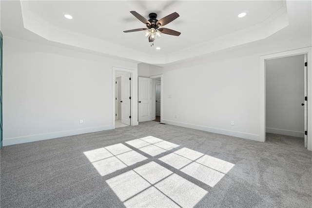 unfurnished bedroom featuring a raised ceiling, light carpet, and ceiling fan