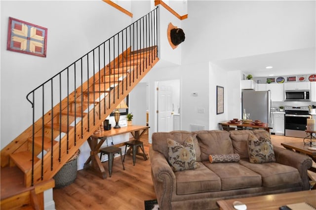 living room featuring a high ceiling and light hardwood / wood-style floors