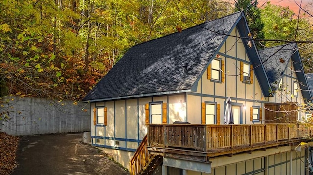 back house at dusk featuring a wooden deck