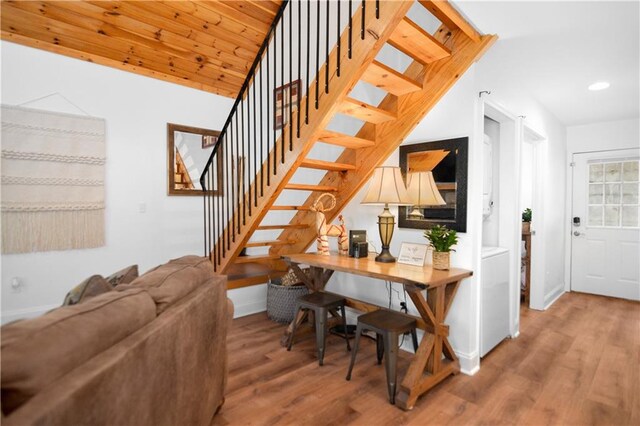 stairs with washer / clothes dryer, wood ceiling, and wood-type flooring