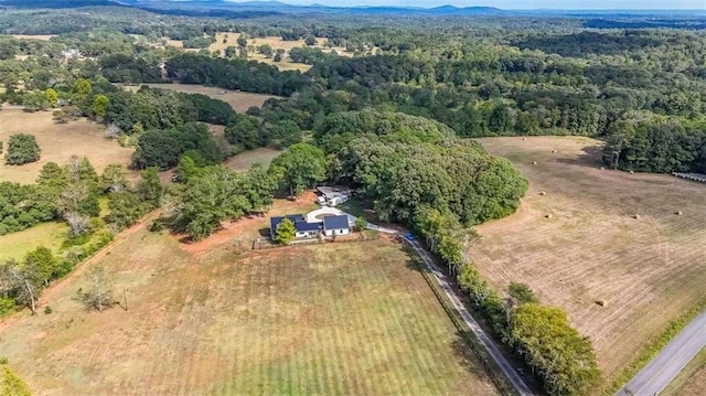 birds eye view of property featuring a rural view, a mountain view, and a view of trees