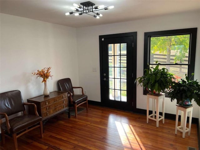 living area with baseboards and wood finished floors