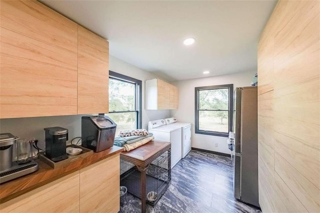 kitchen featuring a wealth of natural light, independent washer and dryer, and light brown cabinetry