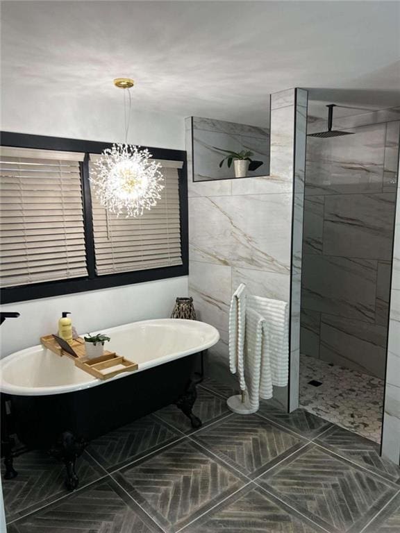 full bath with a chandelier, a walk in shower, and a freestanding tub