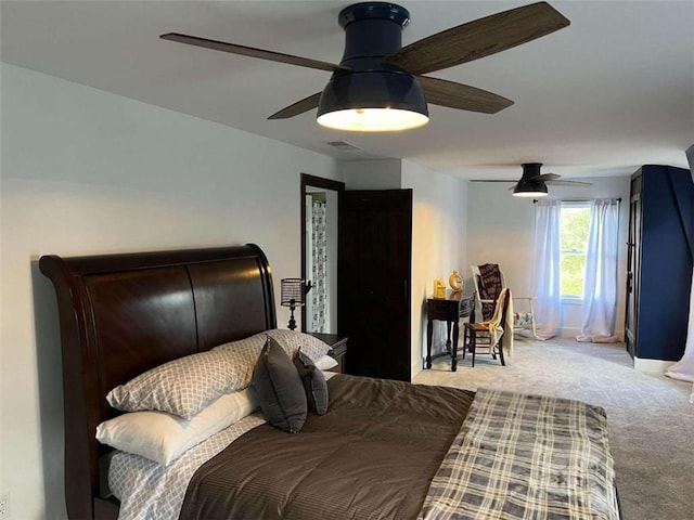 carpeted bedroom featuring baseboards, visible vents, and ceiling fan