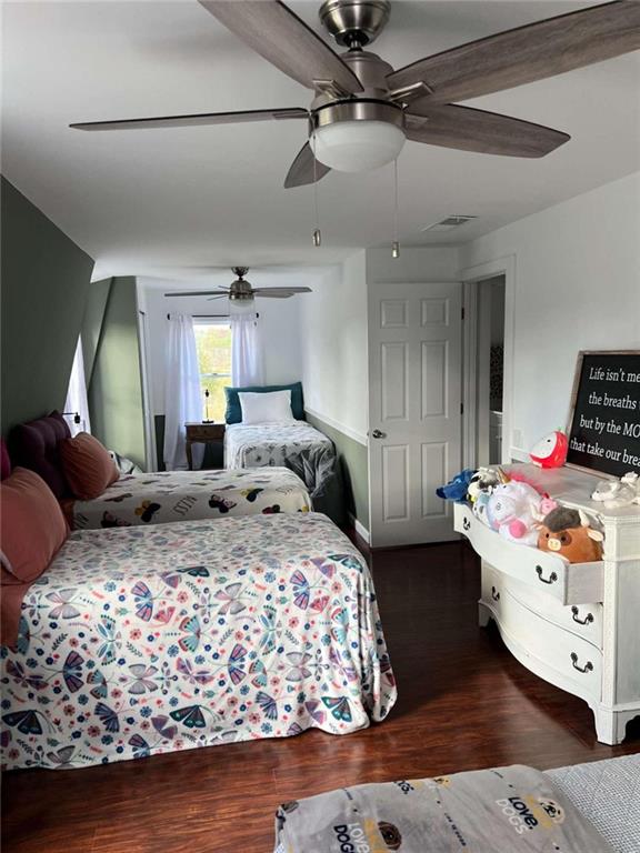 bedroom featuring ceiling fan, visible vents, and wood finished floors