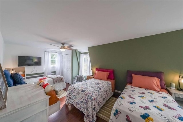 bedroom featuring a closet, baseboards, ceiling fan, and wood finished floors