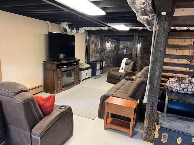 living area featuring a glass covered fireplace, a baseboard radiator, and finished concrete floors