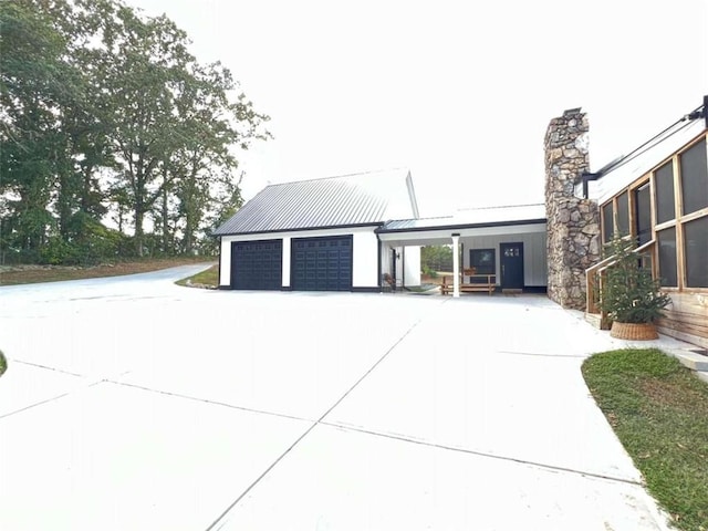 exterior space with a standing seam roof, a garage, and metal roof