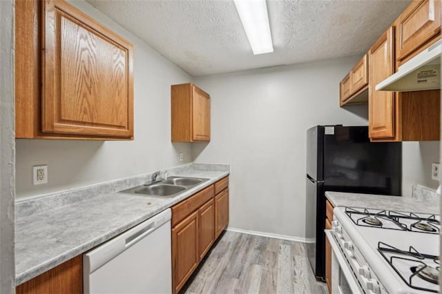 703 Pine Tree Trl, Atlanta, GA 30349 - kitchen featuring sink, white appliances, a textured ceiling, and light wood-type flooring