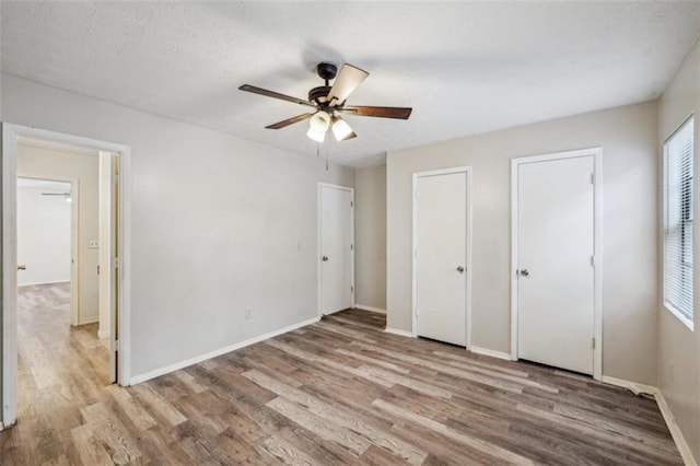 703 Pine Tree Trl, Atlanta, GA 30349 - unfurnished bedroom featuring ceiling fan, two closets, and light hardwood / wood-style floors