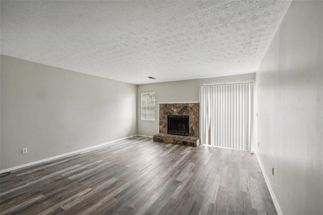 703 Pine Tree Trl, Atlanta, GA 30349 - unfurnished living room featuring a fireplace, a textured ceiling, and dark hardwood / wood-style floors