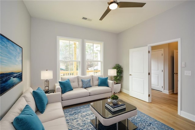 living room with light hardwood / wood-style flooring and ceiling fan