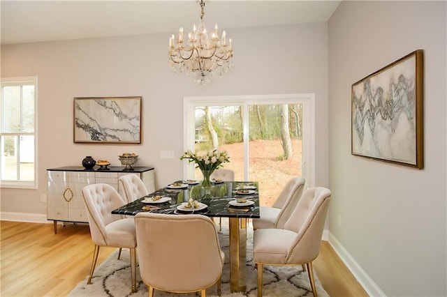 dining space featuring plenty of natural light, hardwood / wood-style floors, and a notable chandelier