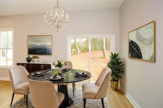 dining room with plenty of natural light, a chandelier, and light wood-type flooring