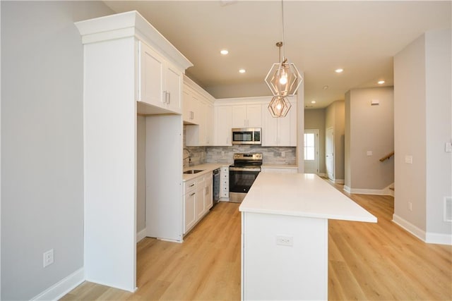 kitchen with white cabinetry, decorative light fixtures, a center island, and appliances with stainless steel finishes