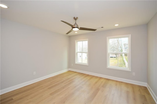 empty room with ceiling fan and light hardwood / wood-style floors