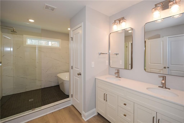 bathroom with independent shower and bath, vanity, and hardwood / wood-style flooring