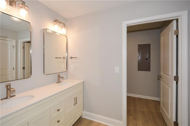 bathroom with hardwood / wood-style flooring, vanity, and electric panel