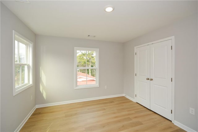 unfurnished bedroom featuring light hardwood / wood-style flooring and a closet