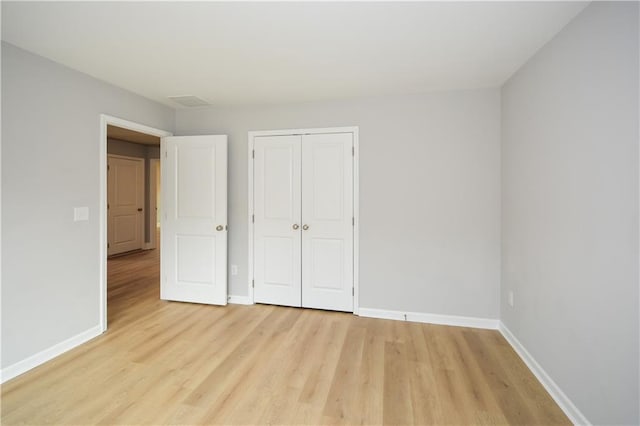 unfurnished bedroom with light hardwood / wood-style floors and a closet