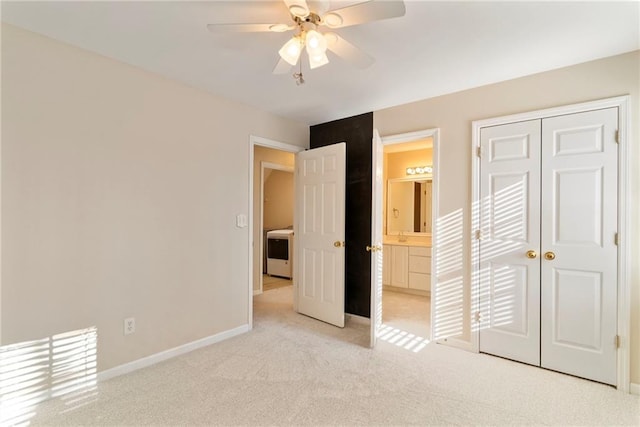 unfurnished bedroom featuring baseboards, light carpet, a closet, washer / clothes dryer, and a ceiling fan